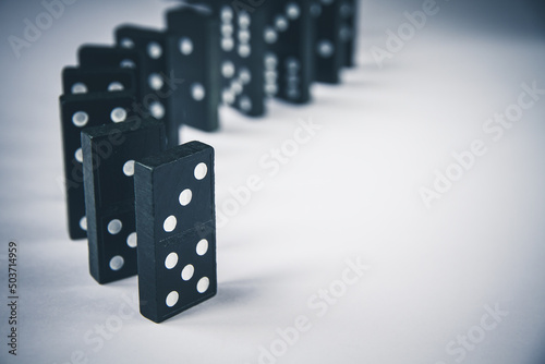 Black dominoes chain on white table background