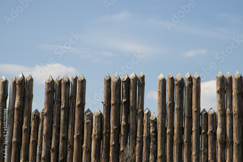 log fence against the blue sky