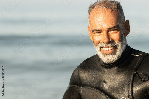 Canvas Print Portrait of a middle-aged African man in a surfing costume on the sea background