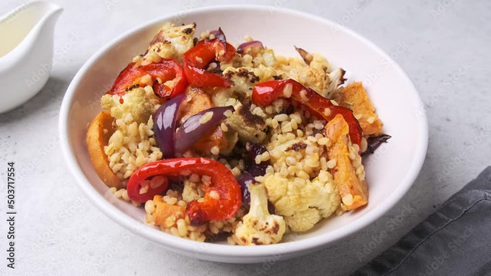 Roasted vegetables salad with bulgur in white bowl. Vegan food concept. Roasted vegetables salad with bulgur in white bowl. Vegan food concept.