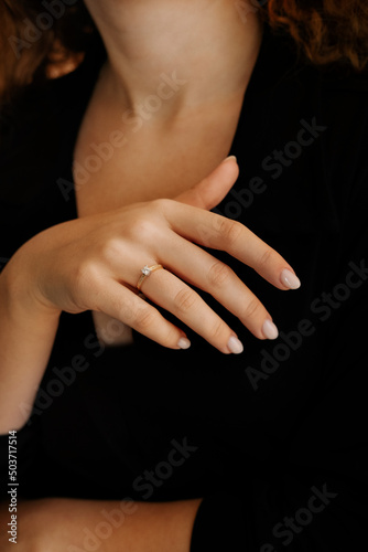 Golden Ring on a female hand, diamonds Diamond ring in hands of young lady. Close-up photo shoot