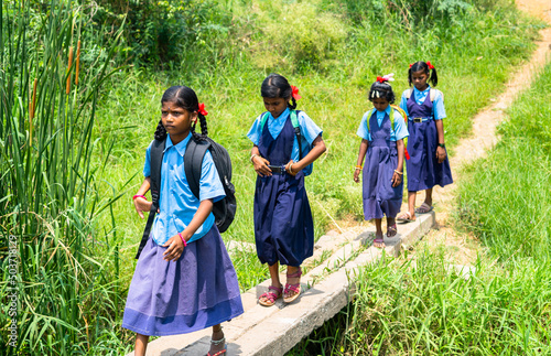 Quadro su tela Group of girl kids going to school by balancingon bridge made up of electric pol