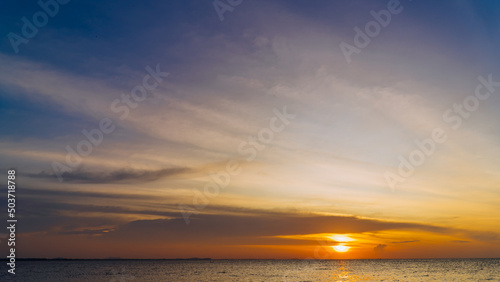 Dusk sky over sea in the evening on twilight with sundown orange sunlight, beautiful sky in summer season