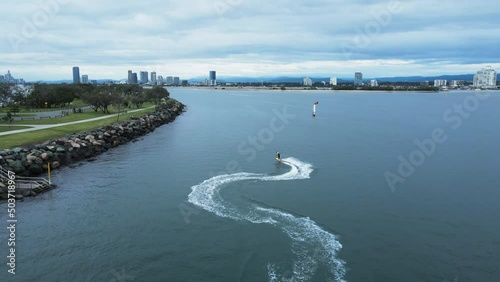 Wallpaper Mural A jet board carves through the glassy waters along a city harbor break wall. Drone view Torontodigital.ca