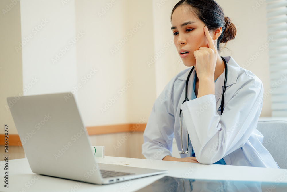 Asian woman doctor in uniform greeting patients online on laptop during on line meeting. Asian woman doctor in uniform greeting patients online on laptop during on line meeting.