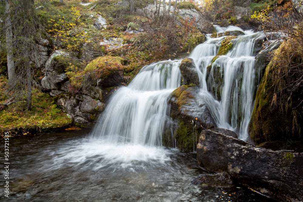 Long exposure of beautiful Kullaoja waterfall in autumn near Naruska, Northern Finland, Europe