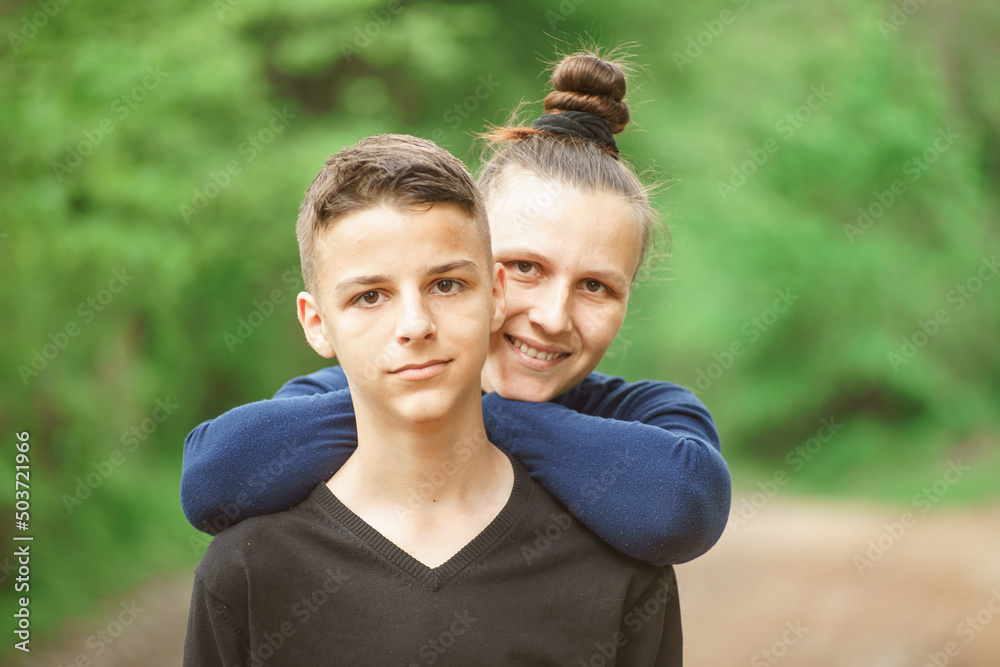 smiling mother and son, portrait in a nature park smiling mother and son, portrait in a nature park