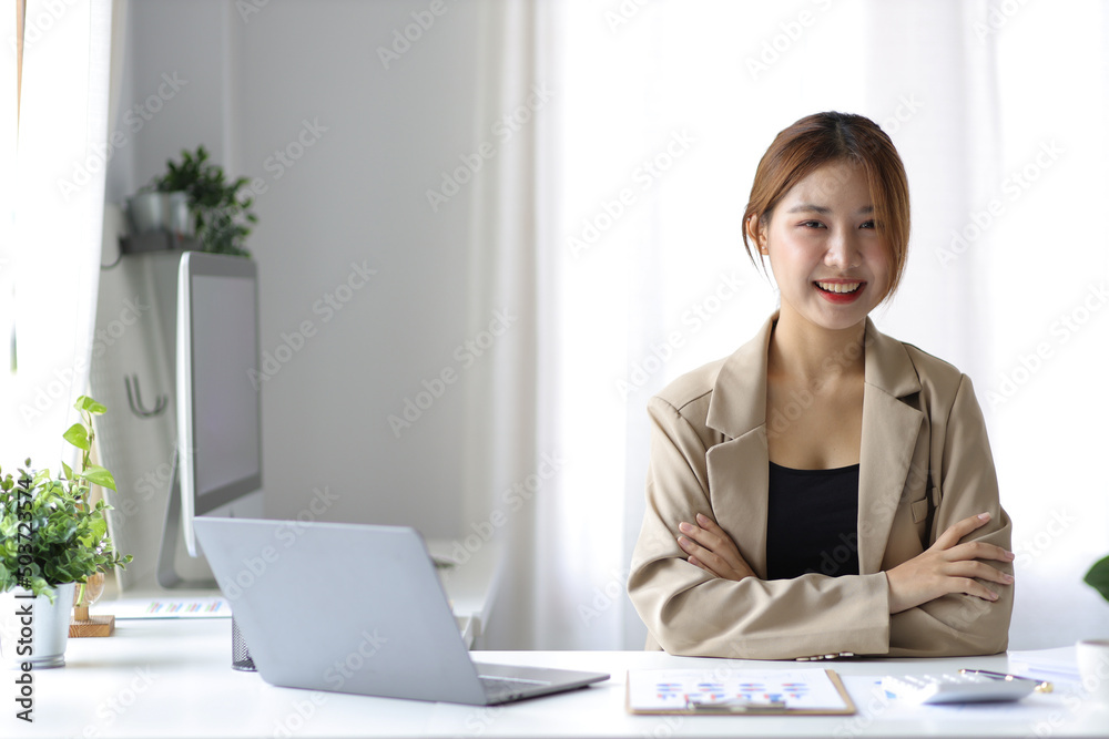 Portrait of a beautiful Asian business woman in the office casually looking at the camera. Portrait of a beautiful Asian business woman in the office casually looking at the camera.