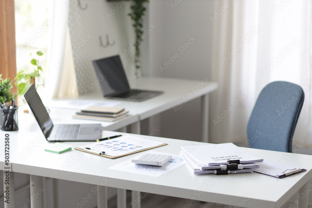 Workplace or office with a desk laptop and documents. Workplace or office with a desk laptop and documents.