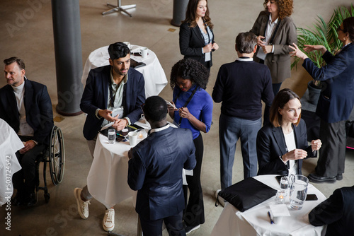 High angle view of professionals discussing with each other during meeting at conference center