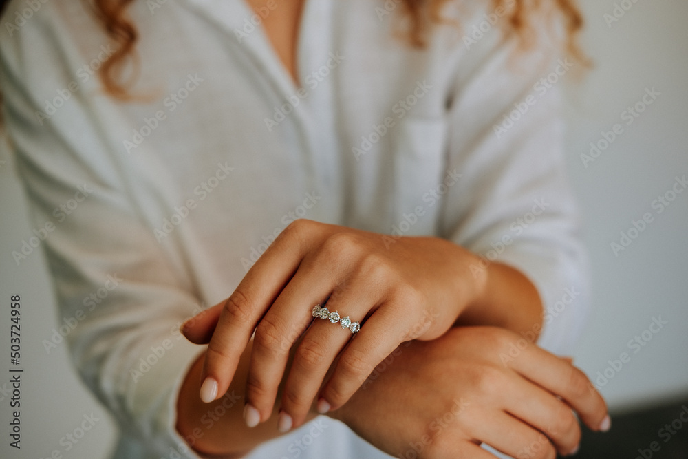 Golden Ring on a female hand, diamonds Diamond ring in hands of young lady. Close-up photo shoot Golden Ring on a female hand, diamonds Diamond ring in hands of young lady. Close-up photo shoot