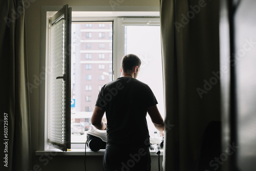 Man washing and cleaning window at home. Housework and housekeeping, home hygiene