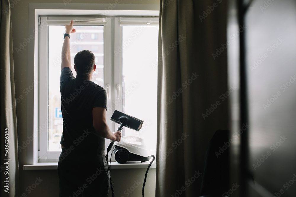 Man washing and cleaning window at home. Housework and housekeeping, home hygiene Man washing and cleaning window at home. Housework and housekeeping, home hygiene
