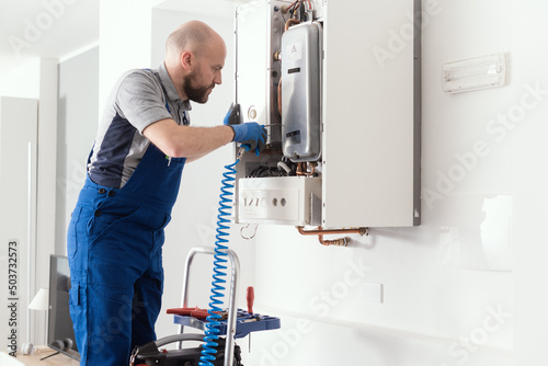 Professional engineer servicing a boiler at home