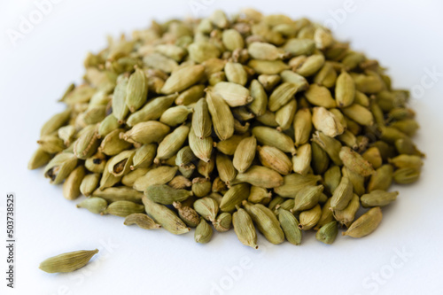 Heap of dry green cardamons on a white background