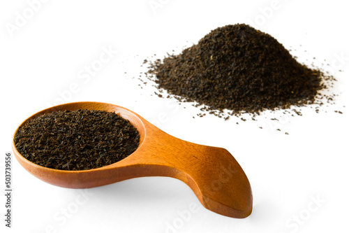 Wooden spoon with Ceylon BOP broken orange pekoe tea and tea leaves on white background