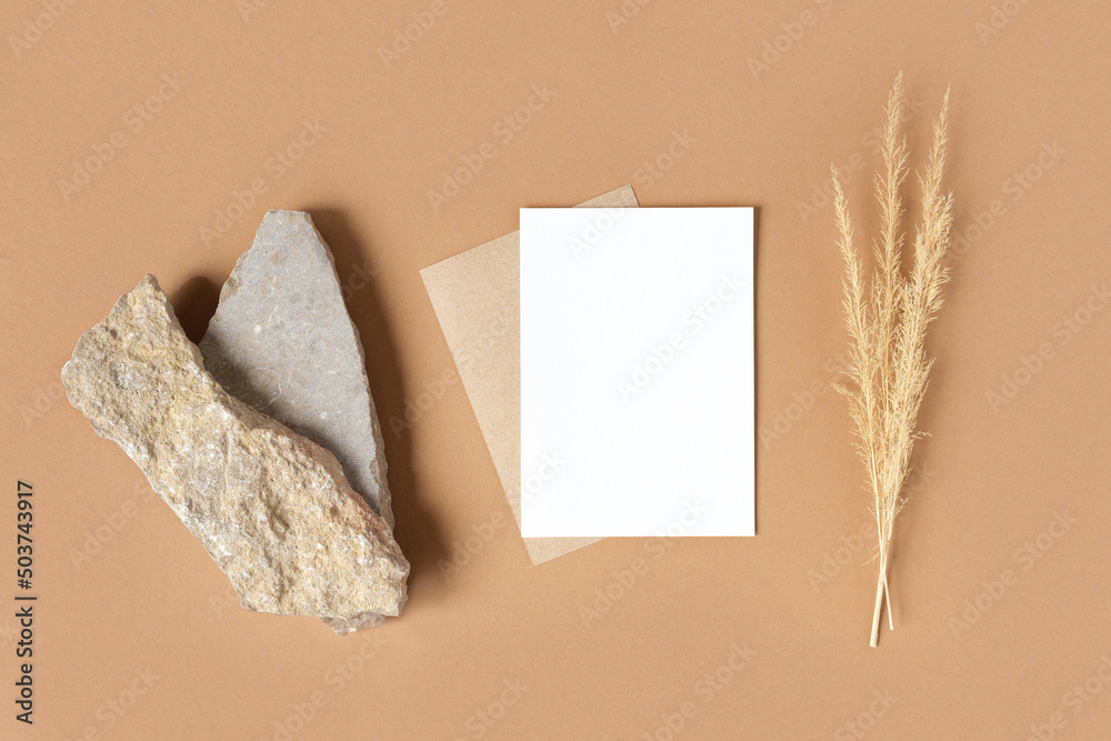 Blank greeting card, invitation mockup. Dry grass, pampas plant on beige table background. Flat lay, top view. Copyspace. Paper cards, mock up. Modern Minimal business brand template. Soft shadow. A6