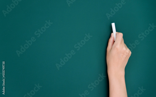 Woman hand writing by chalk on blackboard