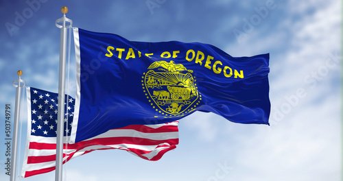 The Oregon state flag waving along with the national flag of the United States of America photo