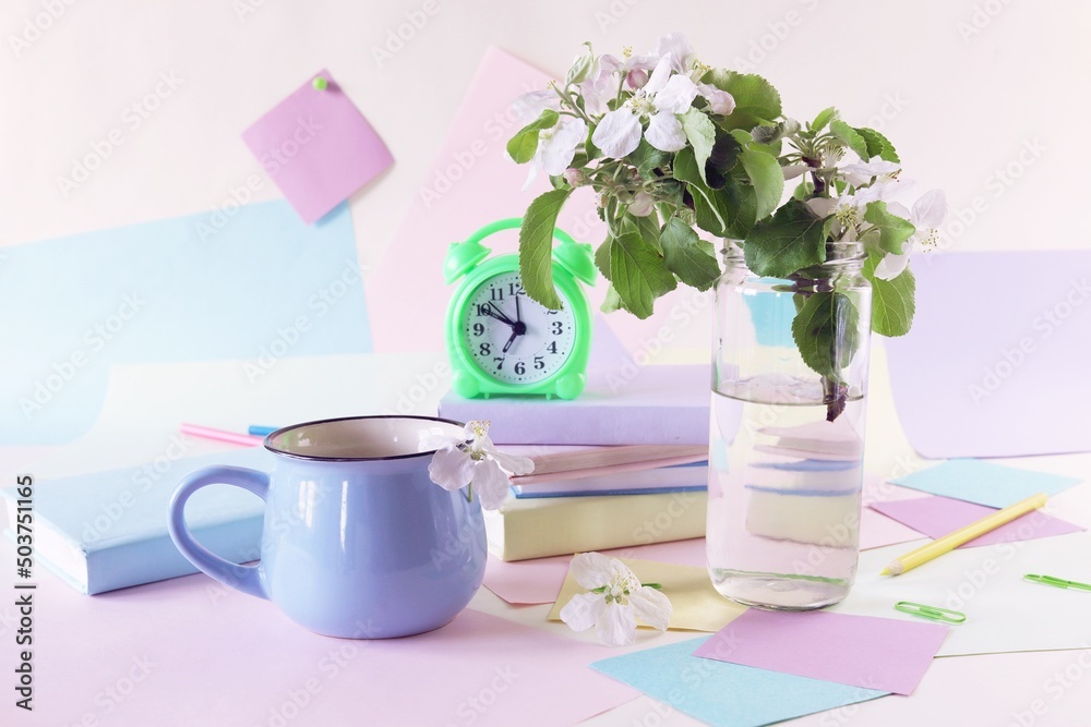 Back to school, alarm clock, apple tree flowers bouquet, stack of books, cup of tea, and stationery on the table, education, vacation time Back to school, alarm clock, apple tree flowers bouquet, stack of books, cup of tea, and stationery on the table, education, vacation time