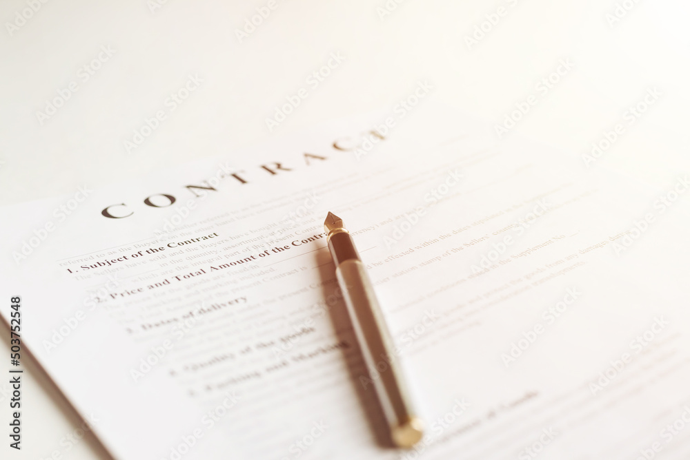 The pen is on the contract and the contract is on a white background. Toned photo The pen is on the contract and the contract is on a white background. Toned photo