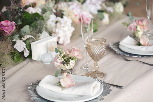 Delicate wedding table setting. A plate with a napkin and a rose. © Artem Zakharov