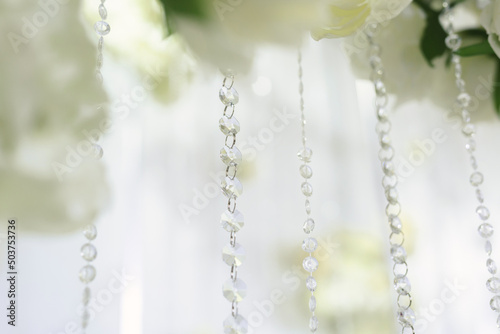 Details of the wedding ceremony made of fresh flowers, sparkling beads. Delicate and beautiful wedding decor for newlyweds. © Artem Zakharov