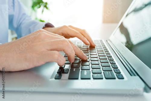 Close-up of businessman using laptop computer in office
