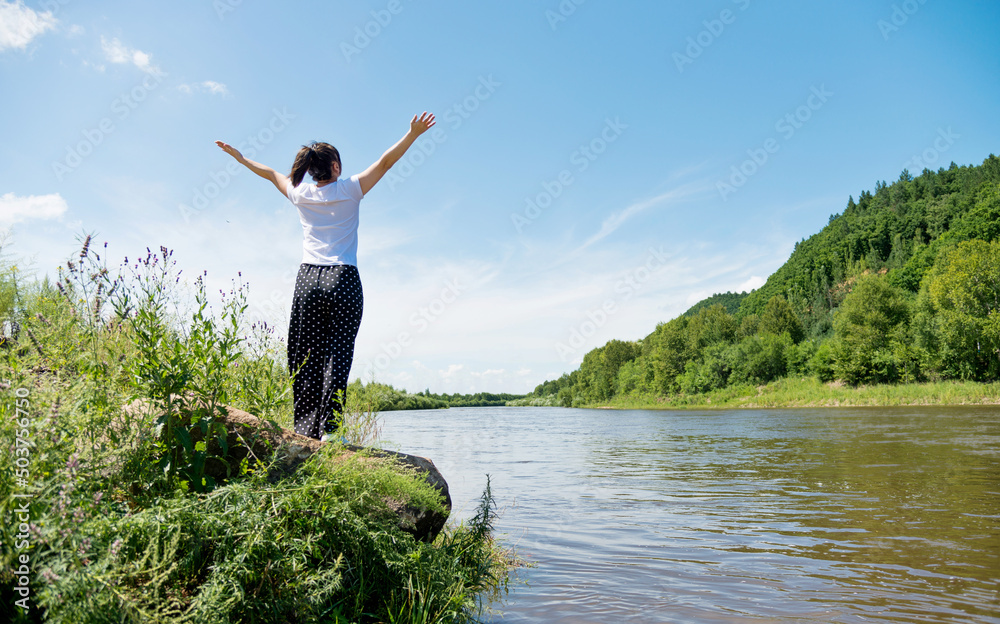 Happy woman with raised arms at lakeside Happy woman with raised arms at lakeside