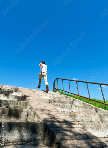 Rear view of young man running up on steps