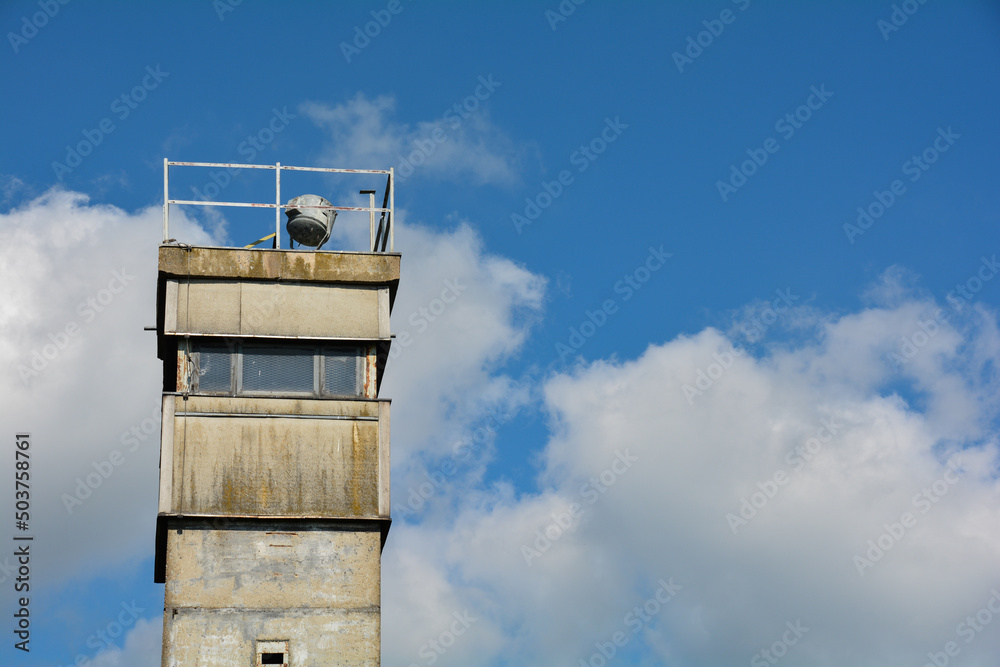 Upper part of an old watchtower at a former GDR border fortification with a blue sky