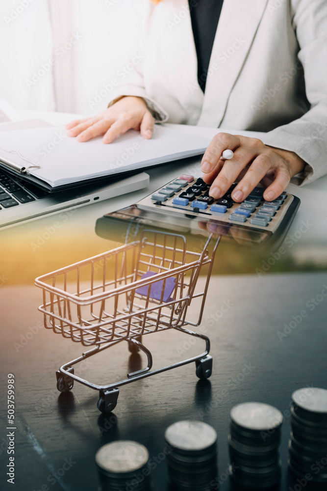 Money (coins), calculator and some stationery on wood table, top view with copy space - financial background concept Money (coins), calculator and some stationery on wood table, top view with copy space - financial background concept