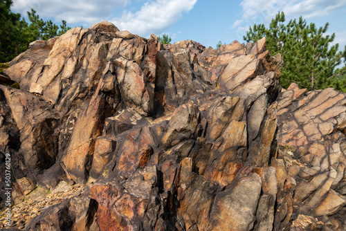 Huge rock formations surrounded by trees under a blue cloudy sky on a sunny day in Sudbury, Ontario photo
