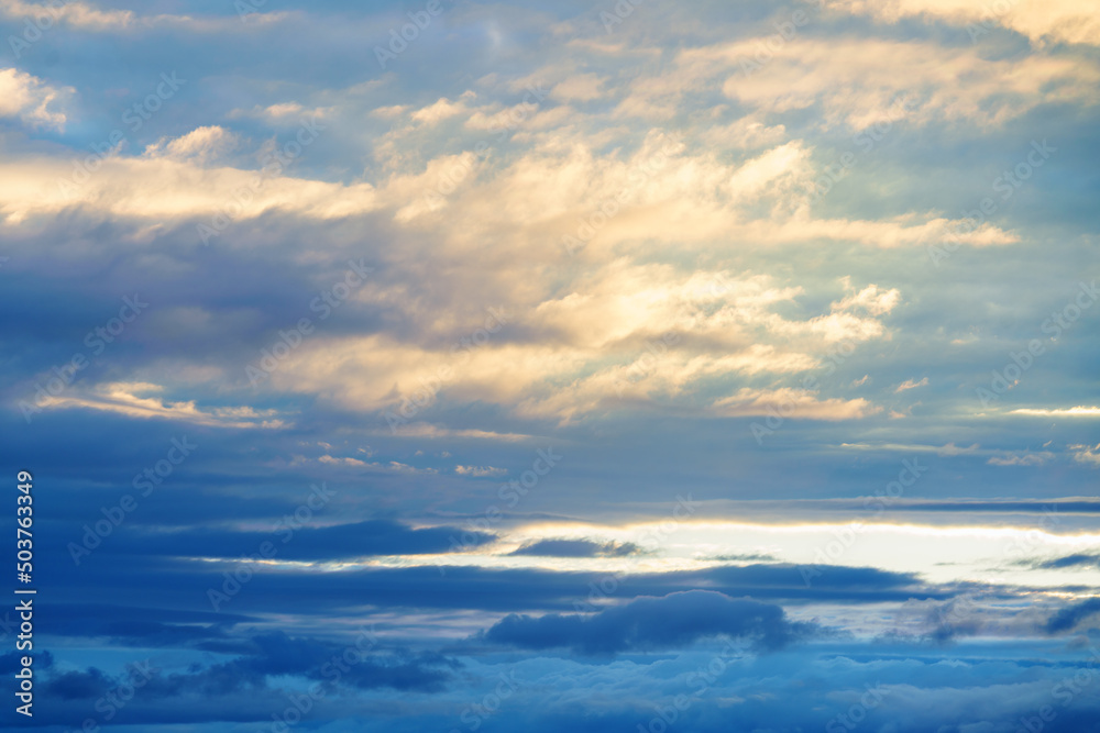 Naklejka premium Clouds illuminated by the setting sun. Great dramatic view. Mystical lighting. Colorful sunset in the evening sky. Amazing sky panorama. Meditative calmness and greatness