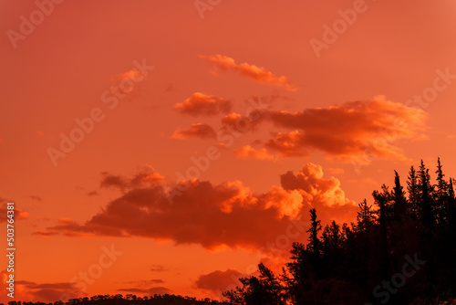 Mystical lighting. Great dramatic view. Amazing sky panorama. Clouds illuminated by the setting sun. Colorful sunset in the evening sky. Meditative calmness and greatness