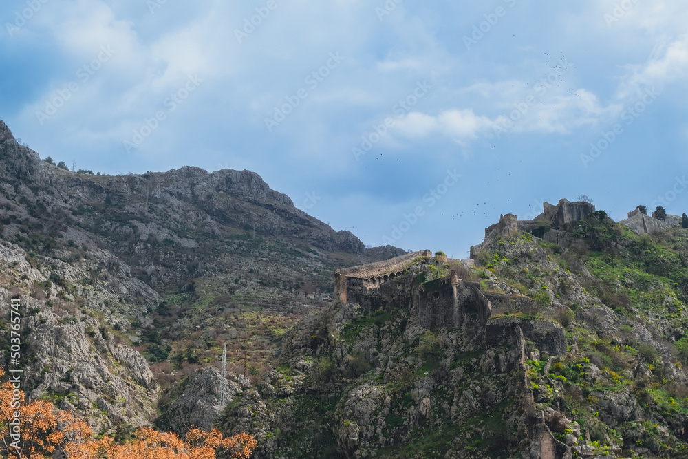 scenic view of the medieval  St John Fortress in the rocky mountains and blue sky, Kotor, Montenegro. travel destination, beautiful natural mountains background, summer hiking trail