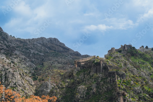 scenic view of the medieval St John Fortress in the rocky mountains and blue sky, Kotor, Montenegro. travel destination, beautiful natural mountains background, summer hiking trail