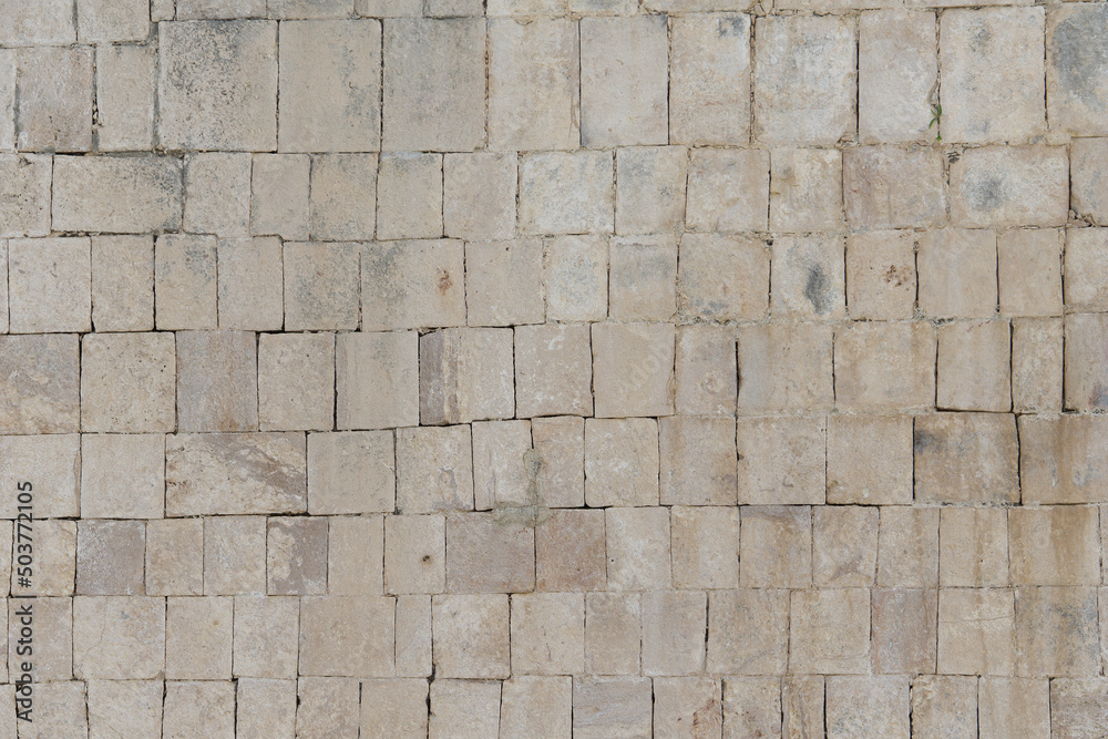 Naklejka premium Ancient masonry wall of the Mayan temple in the city of Chichen Itza. The wall is made of stone blocks.