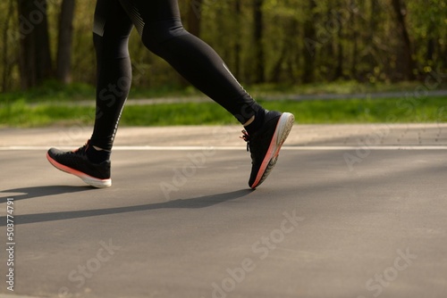 Legs of a running man. Sportswear and footwear. Active lifestyle in the city. Jogging in the park.