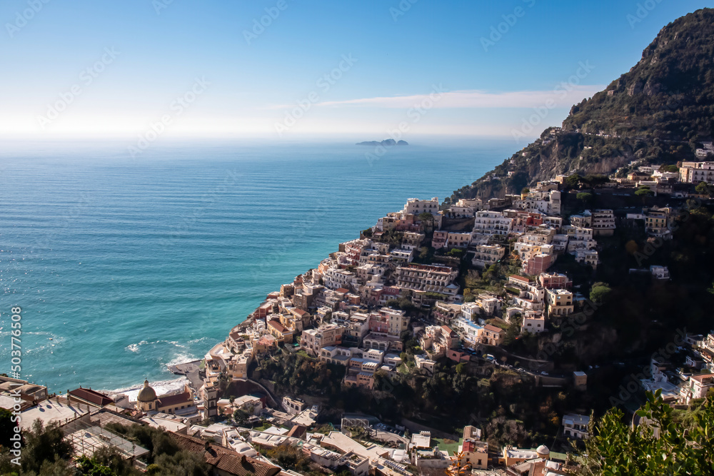 Panoramic view on colorful houses of coastal town Positano, Amalfi Coast, Italy, Campania, Europe. Island in the back. Vacation at coastline at Tyrrhenian, Mediterranean Sea. Path of Gods