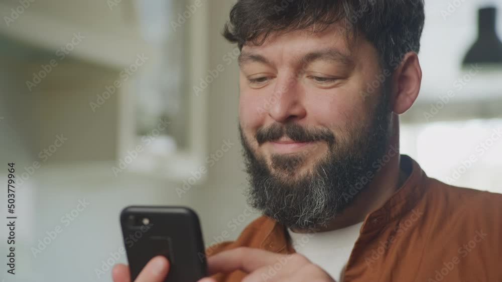 Young adult caucasian man browsing on his smartphone indoors Young adult caucasian man browsing on his smartphone indoors