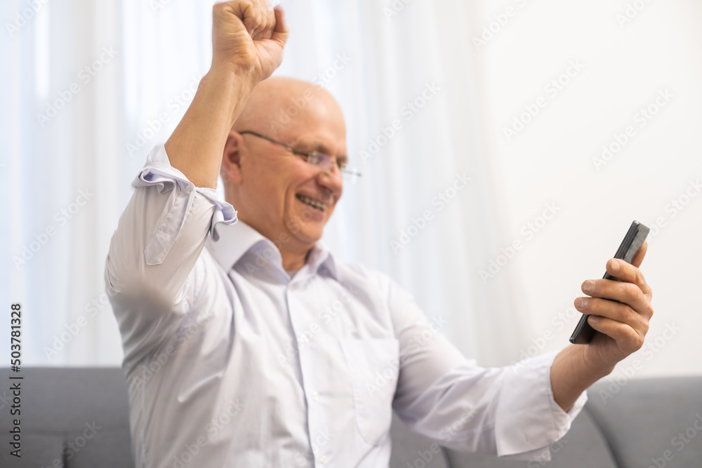 Wow, Great News. Portrait Of Excited Mature Man In Eyeglasses Holding And Using Smartphone, Reading Special Offer, Surprised Male Having Success, Celebrating Win,