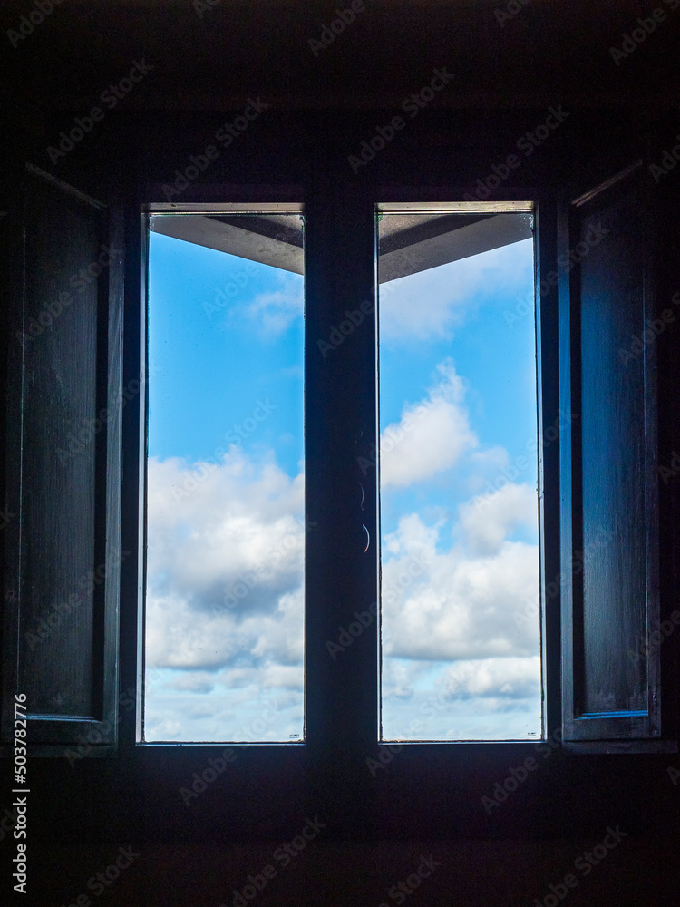 Fototapeta premium Ventana de madera con el cielo con nubes de fondo