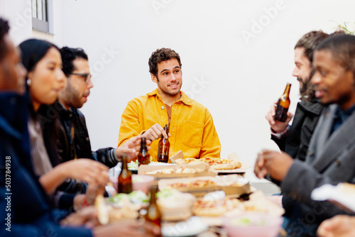 multiracial group of friends celebrating a meal together in a restaurant.