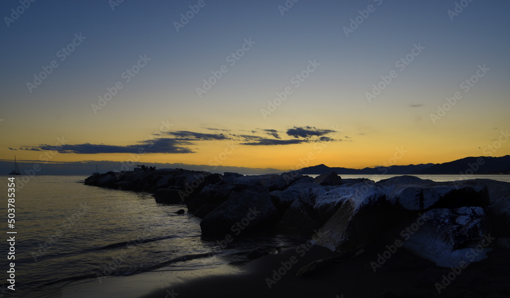 Fototapeta premium incredible colors and lights, a romantic sunset on the beach facing the sea in the magnificent Liguria