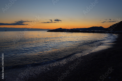 incredible colors and lights, a romantic sunset on the beach facing the sea in the magnificent Liguria © EcoPim-studio
