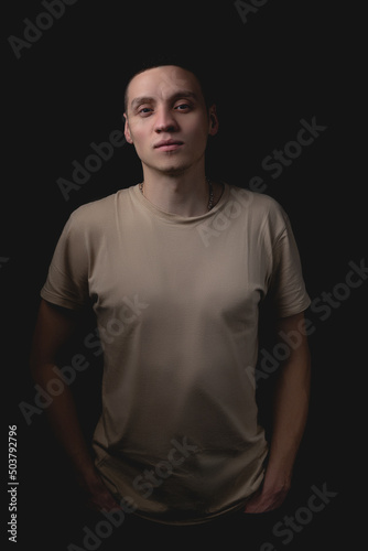 Handsome guy posing in studio on isolated black background. Studio portrait with one light source. © bearok