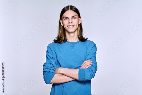 Portrait of smiling positive male looking at camera on light background