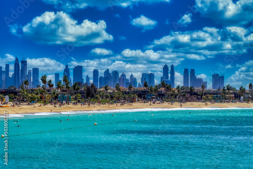 View over sandy beach and Dubai downtown panorama in Dubai, UAE.