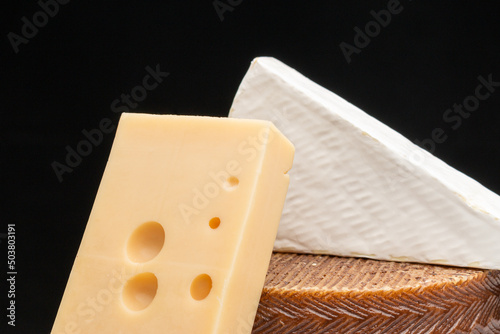 Closeup image of a white Akawi, Cheddar, and Queso Blanco cheese on top of each other photo